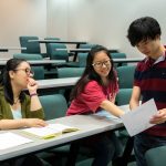 Mathematics professor Jia Wan observes as Mengjin Sun '19 and Nhut Dang '18 study an equation.