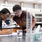 Photo of students looking at a Chemistry experiment in class.