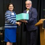 Edna Aguirre Rehbein '77 receives her Alumnae Achievement Award from President Bradley W. Bateman in September 2015.