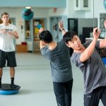 Visiting dance professor Seyong Kim works out with students in Men's Movement class.