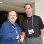 Randolph economics and business professor Jeffery Heinfeldt (right) shakes hands with Timothy Michael, executive director of the Financial Education Association.