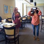 Dung Nguyen '18 (left) and psychology professor Blair Gross watch as Avisha Shah '18 uses the Oculus virtual reality headset.