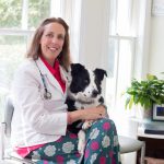 Leslie Jones '93 poses with Dugan, her 3-year-old rescued Border Collie, at her veterinary practice in Midlothian, Virginia.