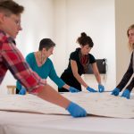 Students work to preserve a painting in the College