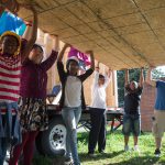 A team of students lifts one of the walls for the tiny house.
