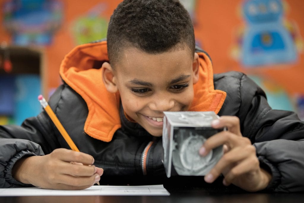 A Dearington Elementary School student examines a block from a Curiosity Kit.