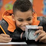 A Dearington Elementary School student examines a block from a Curiosity Kit.