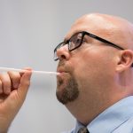 Nicholas Perna leads students on a vocal exercise using straws.