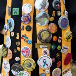 Seniors robes decked out in buttons from various events at the College.