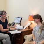 English professor Laura-Gray Street, Celina Matthews '19, and Elsker look through some of the submitted poetry and artwork for their project.