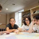 Professor Liz Perry-Sizemore, San Hoang '20, Anh “Jessica” Bui ’20, and Leo Cohen look at a map of Lynchburg.