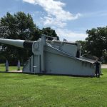 Alex Clem '19 stands next to a cannon used on a ship in WWII.