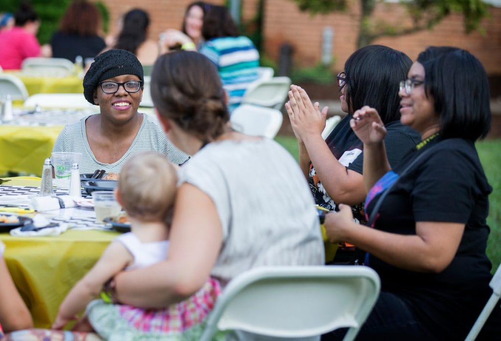 Students and alumnae have conversations over dinner at the College Community Cookout