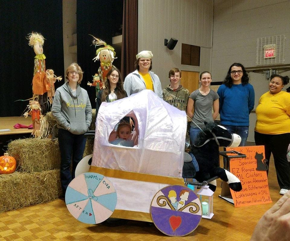 Randolph students pose with Maddie, age 6, in her Cinderella-themed costume, 