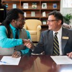 Nick George, founder and executive director of The Listening, and Carl Girelli, vice president for academic affairs and dean of Randolph College, shake hands following the announcement of the new partnership.