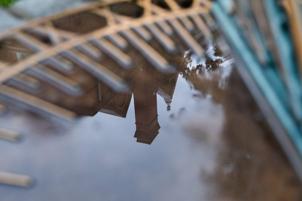 Rainwater on the Sundial shows the reflection of campus buildings