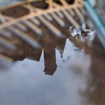 Rainwater on the Sundial shows the reflection of campus buildings