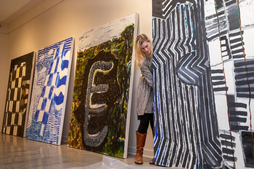 Elisabeth Ayars '19 sets up paintings for the spring exhibitions that will open this Friday.