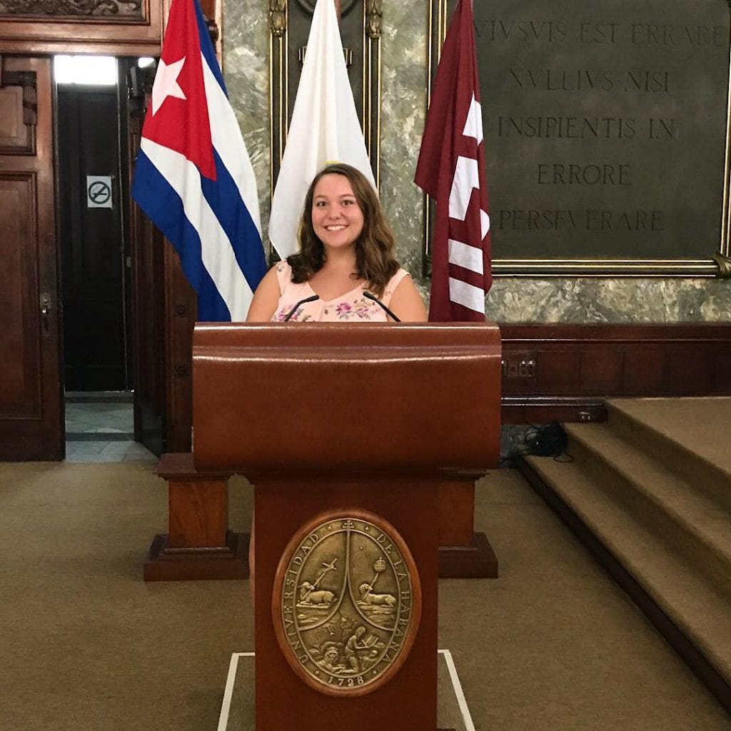 Lauren Appel '20 at the podium in a Cuban government building