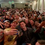 Students take selfies in the audience