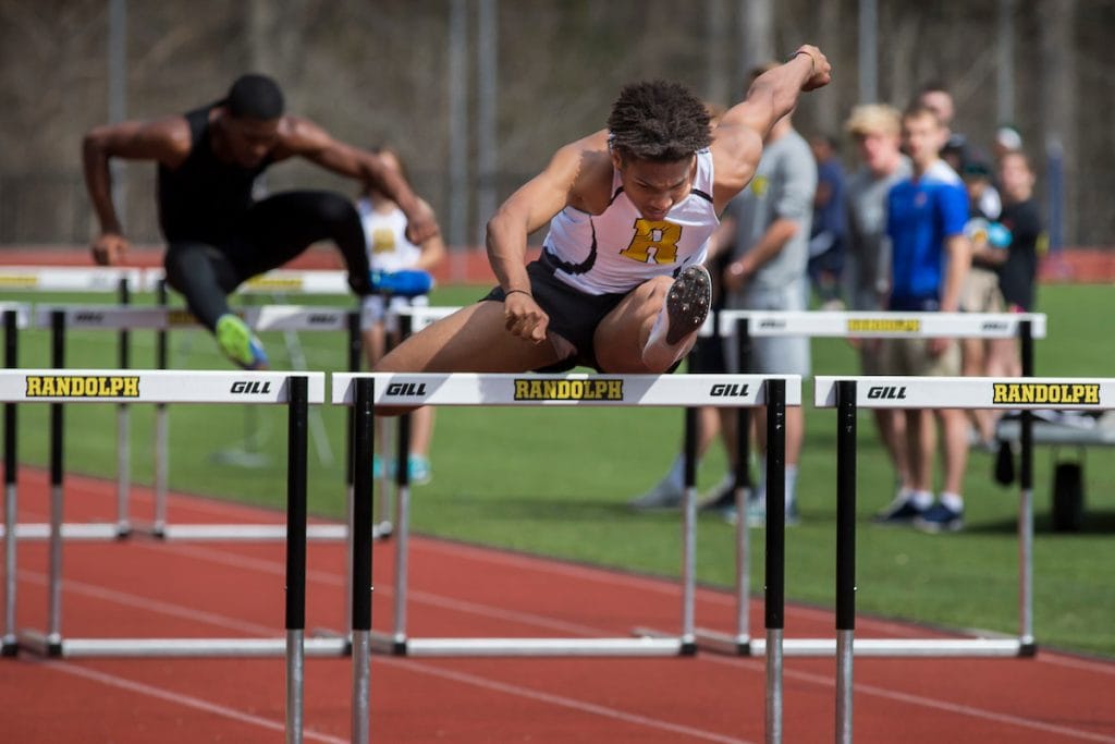 DJ Petty '20 jumps a hurdle at a Randolph track meet in 2018