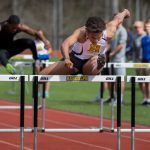 DJ Petty '20 jumps a hurdle at a Randolph track meet in 2018