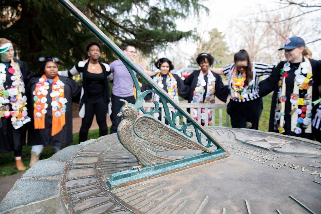 Students sing school songs around the Sundial