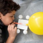 Students blow up balloons for a propelled car at Science Festival.