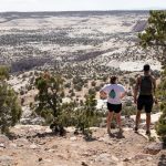 Two students stand on an overlook of the desert