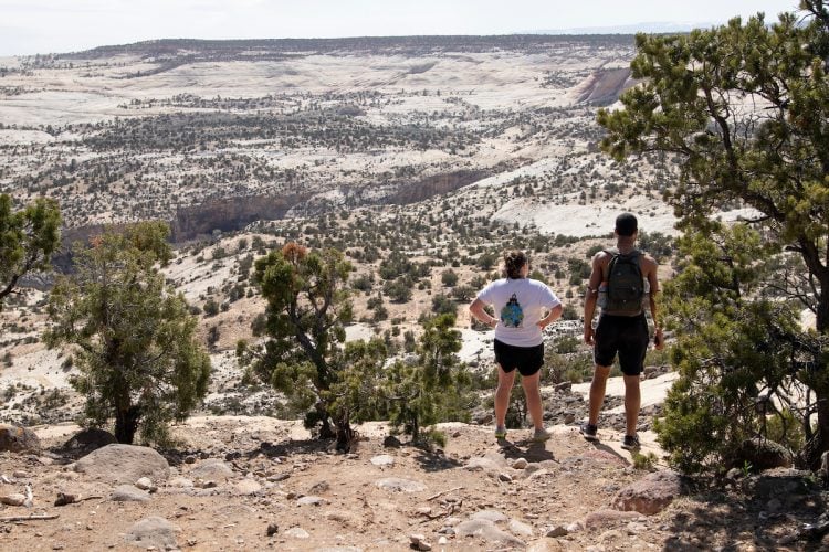 Two students stand on an overlook of the desert Two students stand on an overlook of the desert