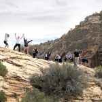 Students pose on top of a desert mountain