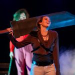 A character laughs as she holds up a weapon in She Kills Monsters