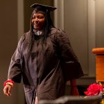 A graduate walks across the stage