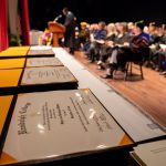 Diplomas sit on the table by the stage