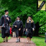 Graduates walk along the Red Brick Path on front campus