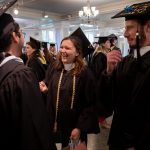 Graduates laugh before lining up to process into Smith Hall Theatre