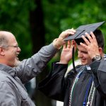 A family member straightens a graduate