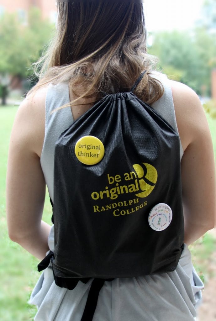 A Randolph College student shows off her Be An Original backpack and button collection.