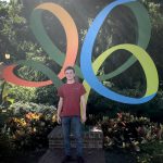 Cody Carpenter in front of a large statue of the Busch Gardens logo