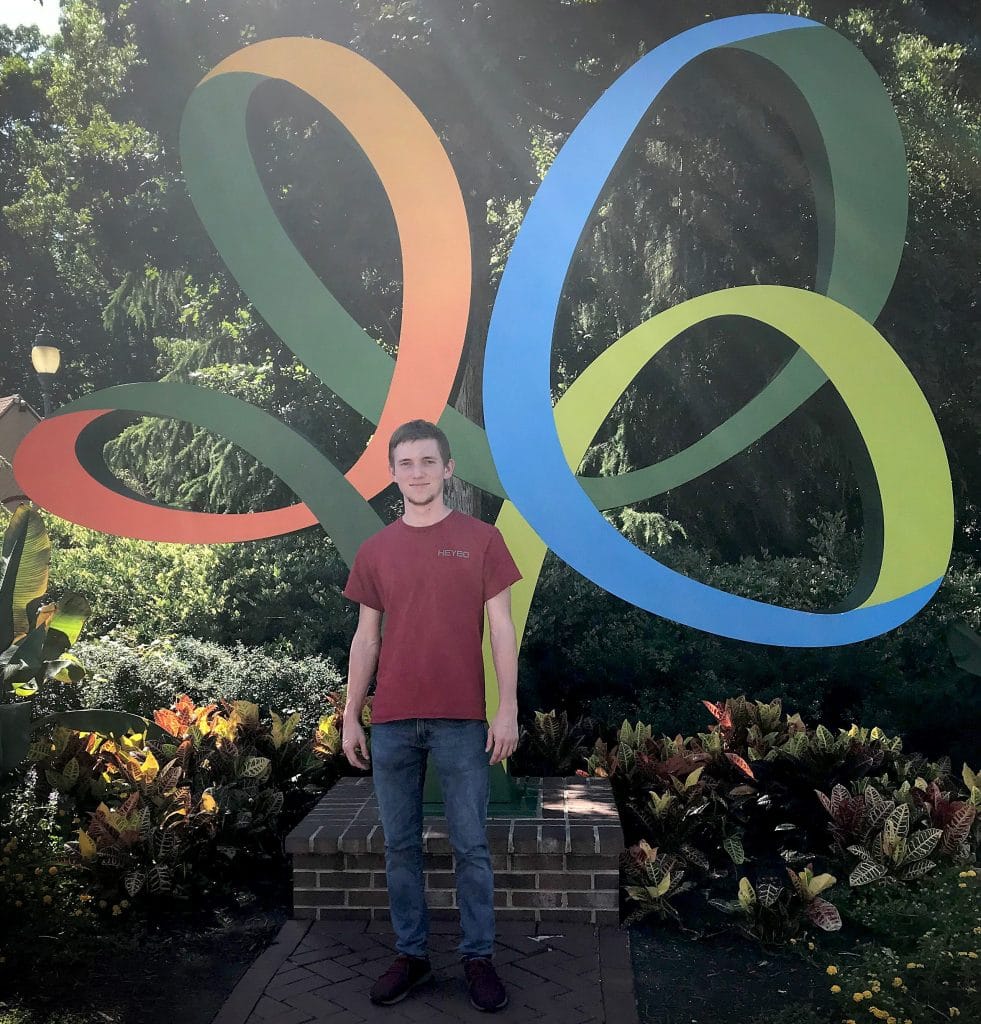 Cody Carpenter in front of a large statue of the Busch Gardens logo