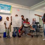Students dance and chant while their mentors cheer them on