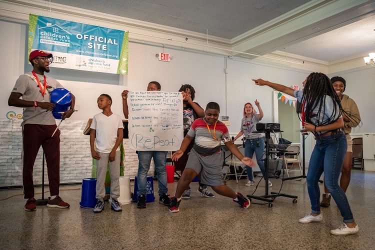Students dance and chant while their mentors cheer them on Students dance and chant while their mentors cheer them on