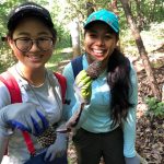 Keyu Jin and Priscilla Ranjitkar examine pine cones in the forest
