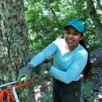 Priscilla Ranjitkar measures the base of a tree in one of the forests the group is surveying
