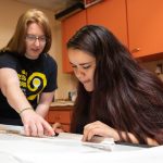 Professor Heather Sinclair (left) and Karyn Heisig draw stage renderings