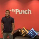 Jared Ruddock in front of red wall with Punch logo on it