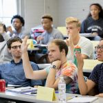 Students in the 2018 SUPER program raise their hands during a classroom activity