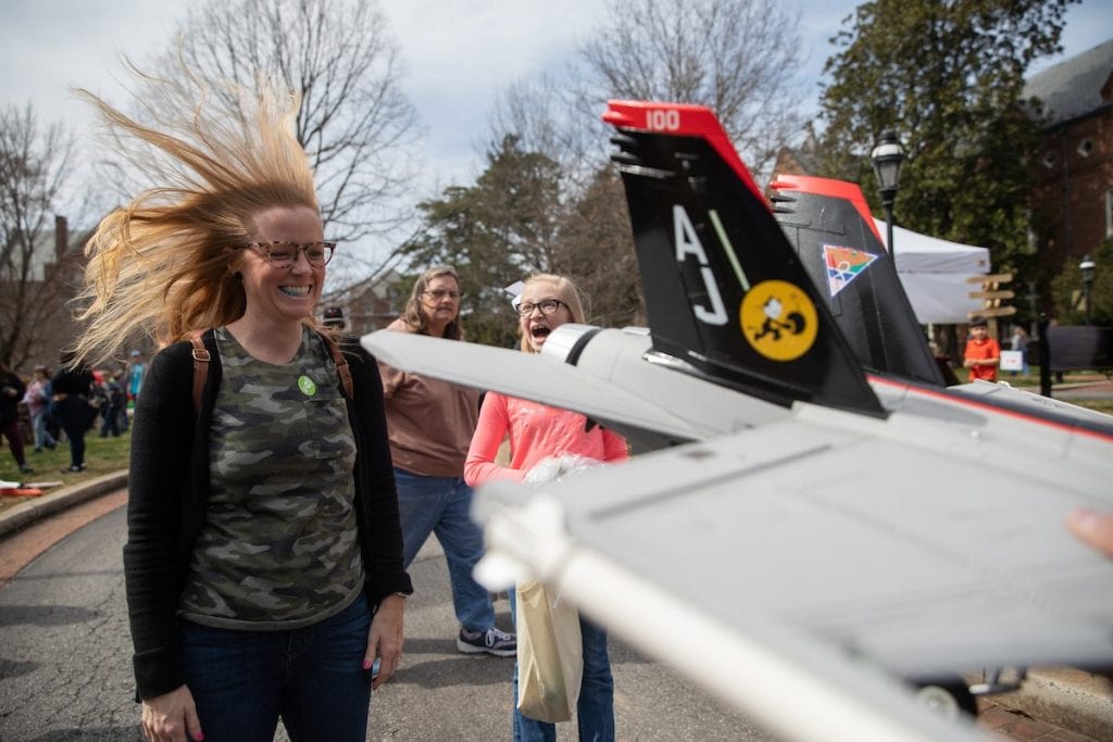 A visitor gets her hair blown back by a mini jet engine at the 2019 Science Festival.