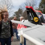 A visitor gets her hair blown back by a mini jet engine at the 2019 Science Festival.