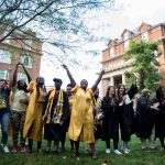 Students sing school songs by the Sundial